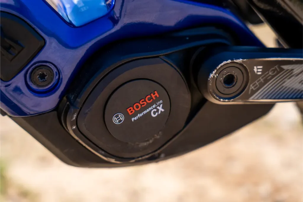 Primer plano de un motor Bosch Performance Line CX en una bicicleta eléctrica, en el que se aprecia el logotipo de Bosch y parte de una biela con la inscripción «Affect». Se destaca la actualización Bosch Performance Upgrade para obtener más potencia y más control en cada recorrido.