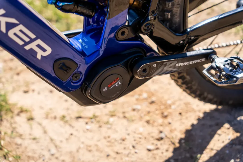 Primer plano de un motor Bosch Performance Line CX equipado con la actualización «Bosch Performance Upgrade» para un mayor control y potencia, junto con un juego de bielas Race Face montado en el cuadro de una bicicleta de montaña eléctrica.