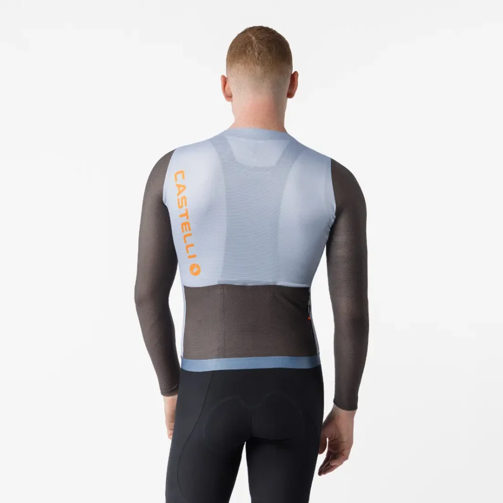 Una persona aparece de espaldas, vestida con un maillot Corretto LS de manga larga con la inscripción «Castelli» en la espalda y unos culotes negros de ciclismo, sobre un fondo blanco liso.