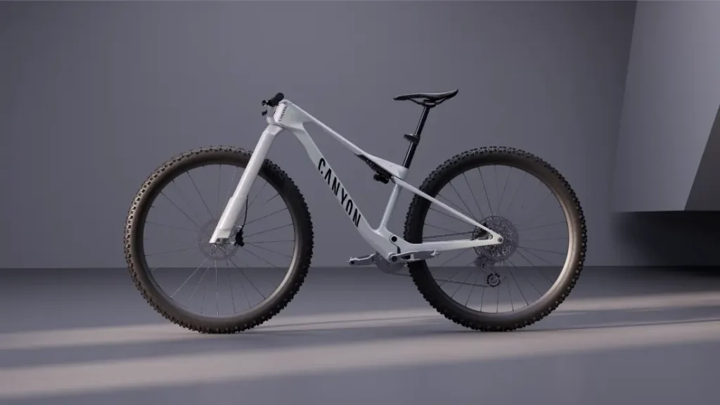 Una moderna bicicleta de montaña Canyon blanca, con ruedas anchas de 32 y un diseño minimalista, se exhibe en un entorno interior sencillo y gris, con una iluminación tenue.
