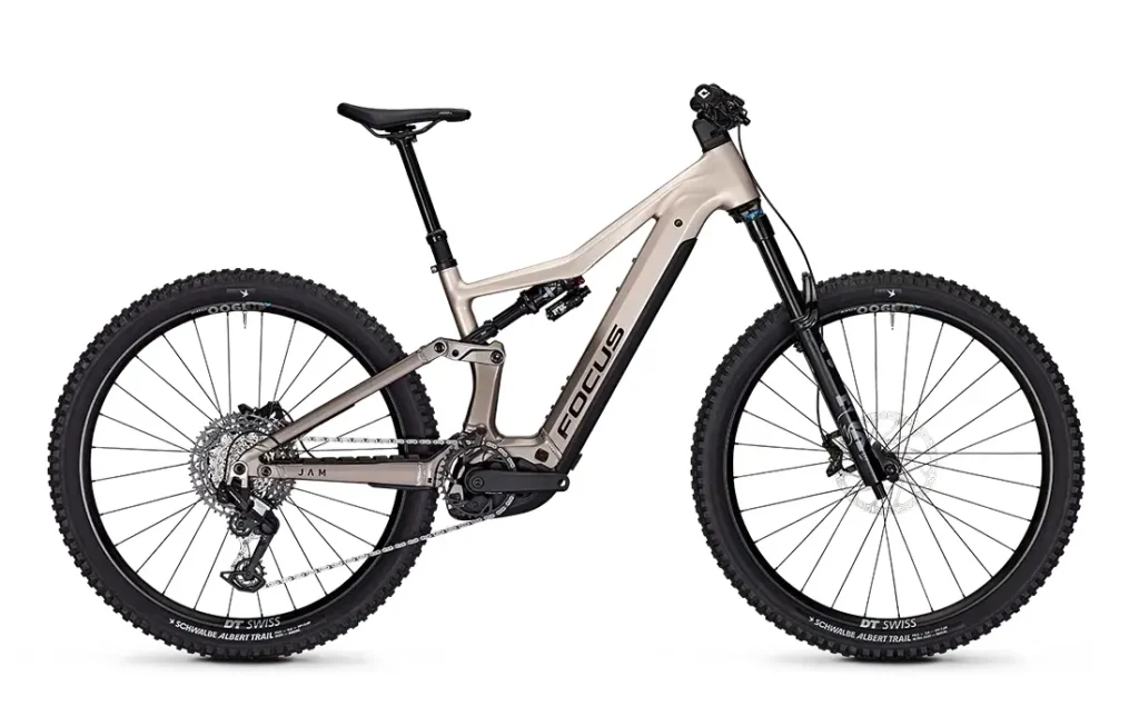 La Gama FOCUS e-MTB 2027, una bicicleta de montaña eléctrica con suspensión total, neumáticos anchos, frenos de disco hidráulicos y un motor de tracción central, se presenta en un entorno neutro de estudio.