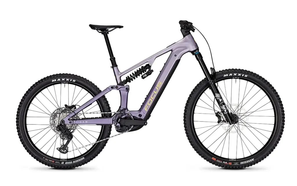 Bicicleta eléctrica de montaña (e-MTB) Purple JAM de suspensión total, modelo 2027, con frenos de disco, neumáticos anchos y un sistema de motor central, mostrada de perfil sobre un fondo blanco.