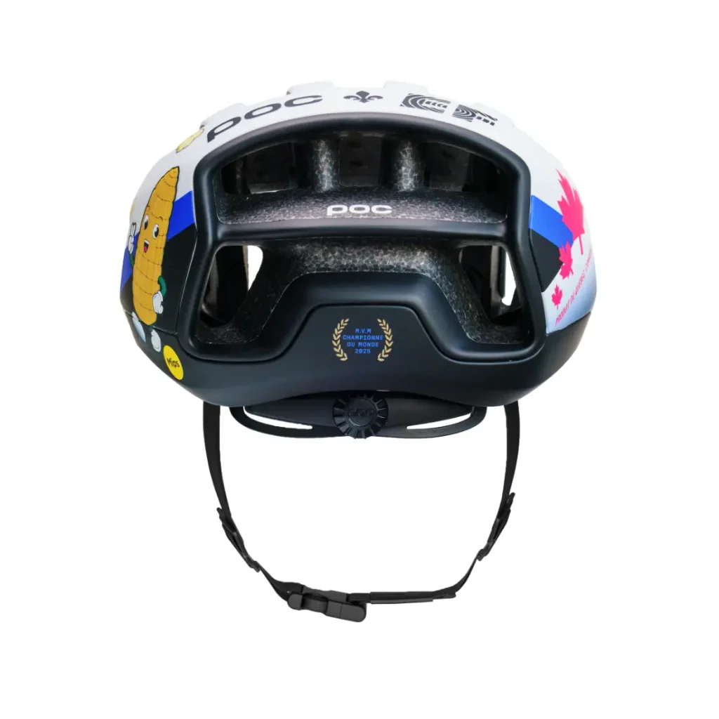 Un casco de bicicleta blanco y negro con dibujos de mazorcas de maíz, una hoja de arce y detalles en azul, visto desde atrás con la correa de la barbilla colgando.