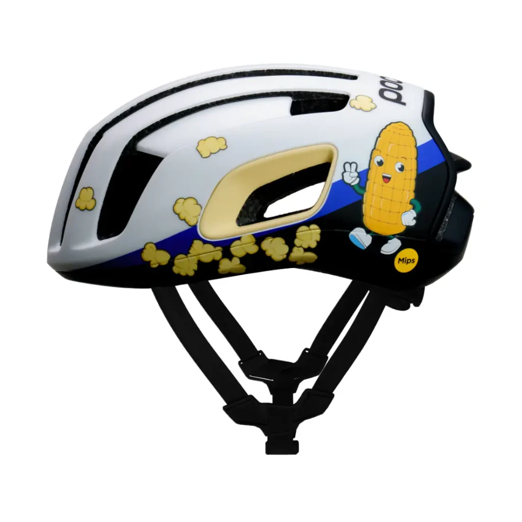 Casco de bicicleta blanco y negro decorado con imágenes de palomitas y un personaje animado de maíz sonriente, visto de perfil.
