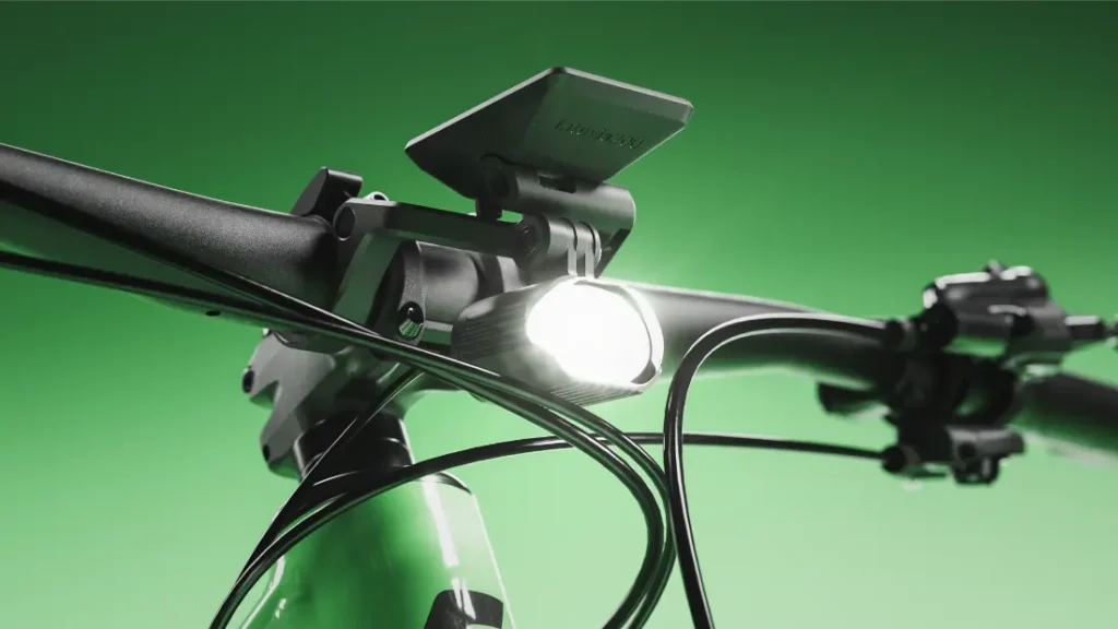 Primer plano del manillar de una bicicleta SCOTT Strike 2027 con un faro delantero encendido y una pantalla digital, sobre un fondo verde, que destaca la comodidad y la avanzada integración del motor Bosch CX.