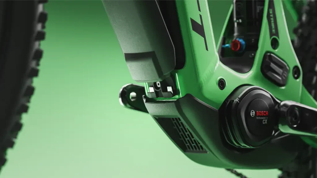 Primer plano del cuadro verde de una bicicleta eléctrica SCOTT Strike 2027, en el que destacan el motor Bosch CX Performance Line y el compartimento de la batería sobre un fondo verde, para ofrecer el máximo confort y estilo.