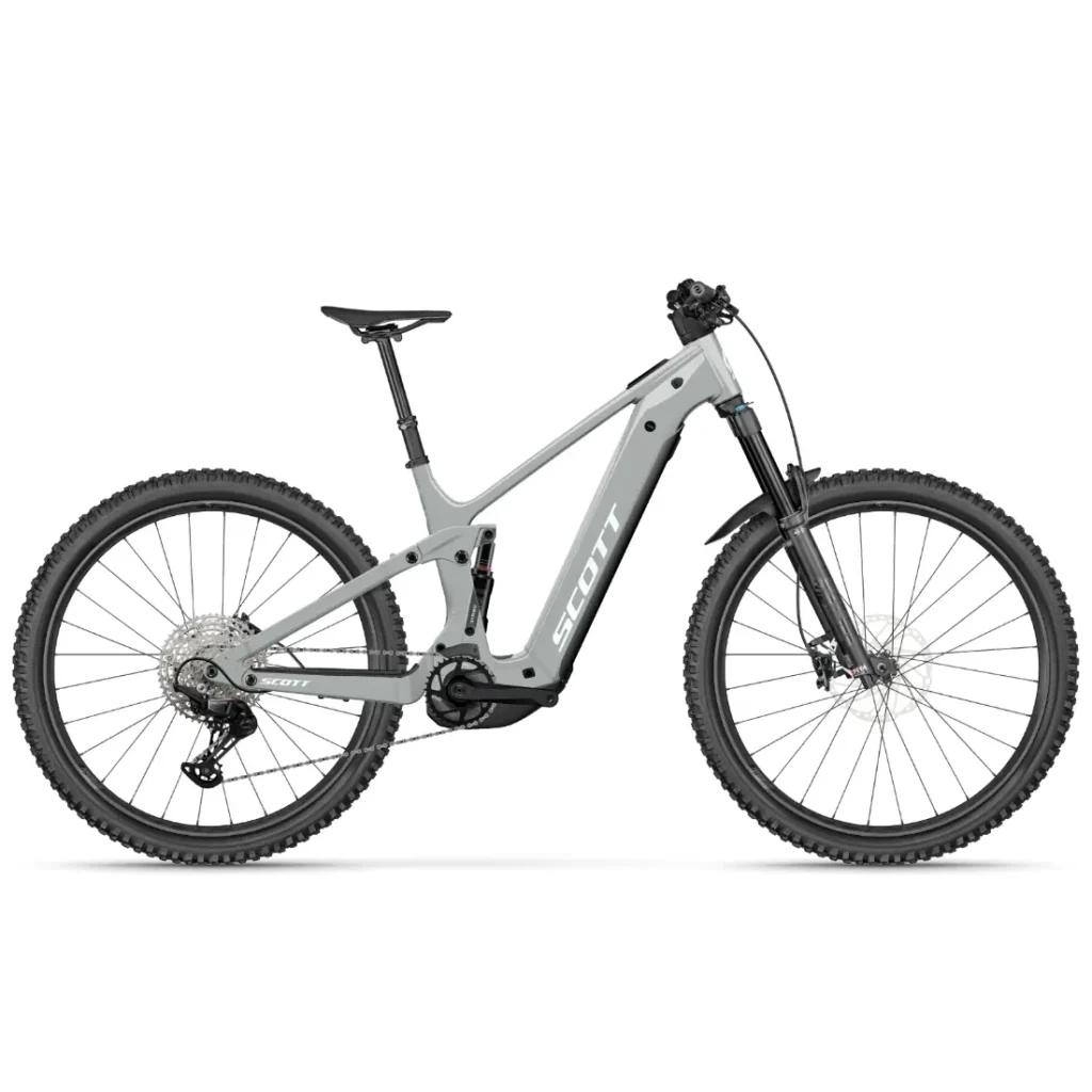 Una bicicleta eléctrica de montaña SCOTT Strike 2027 de color gris, con neumáticos anchos, batería central y suspensión delantera, ofrece una comodidad excepcional, realzada por su potente motor Bosch CX; fotografiada de perfil sobre un fondo blanco.