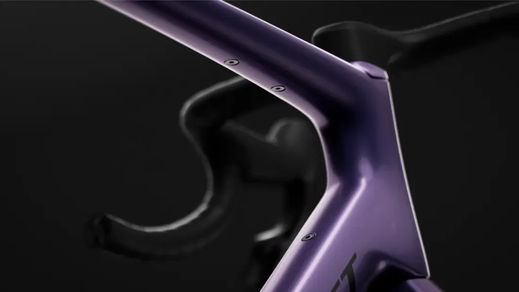 Primer plano del manillar y la potencia de una bicicleta SCOTT Addict Gravel 2027 de color morado mate sobre un fondo oscuro, en el que destacan sus líneas suaves y el diseño integrado y polivalente de esta bicicleta de gravel.