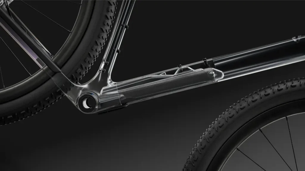 Primer plano del cuadro polivalente de la bicicleta SCOTT Addict Gravel 2027, con una sección transparente que muestra el paso interno de los cables y dos ruedas parcialmente visibles sobre un fondo oscuro. El diseño destaca lo cómoda y elegante que resulta la bicicleta, perfecta para salidas versátiles.