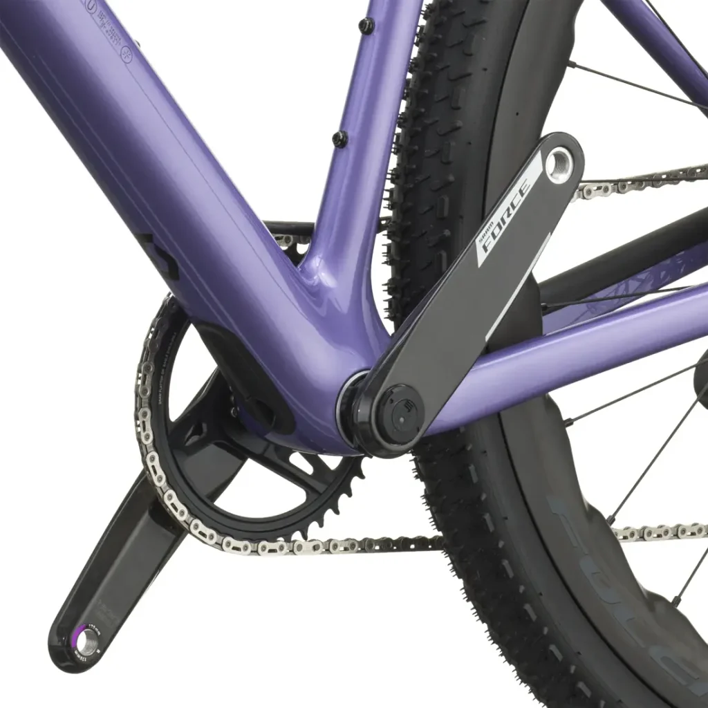 Primer plano del cuadro de la bicicleta polivalente SCOTT Addict Gravel 2027 de color morado, en el que se aprecian el juego de bielas, el plato, la cadena y la rueda trasera con dibujo de banda de rodadura para grava, ideal para cualquier aventura en bicicleta de grava.
