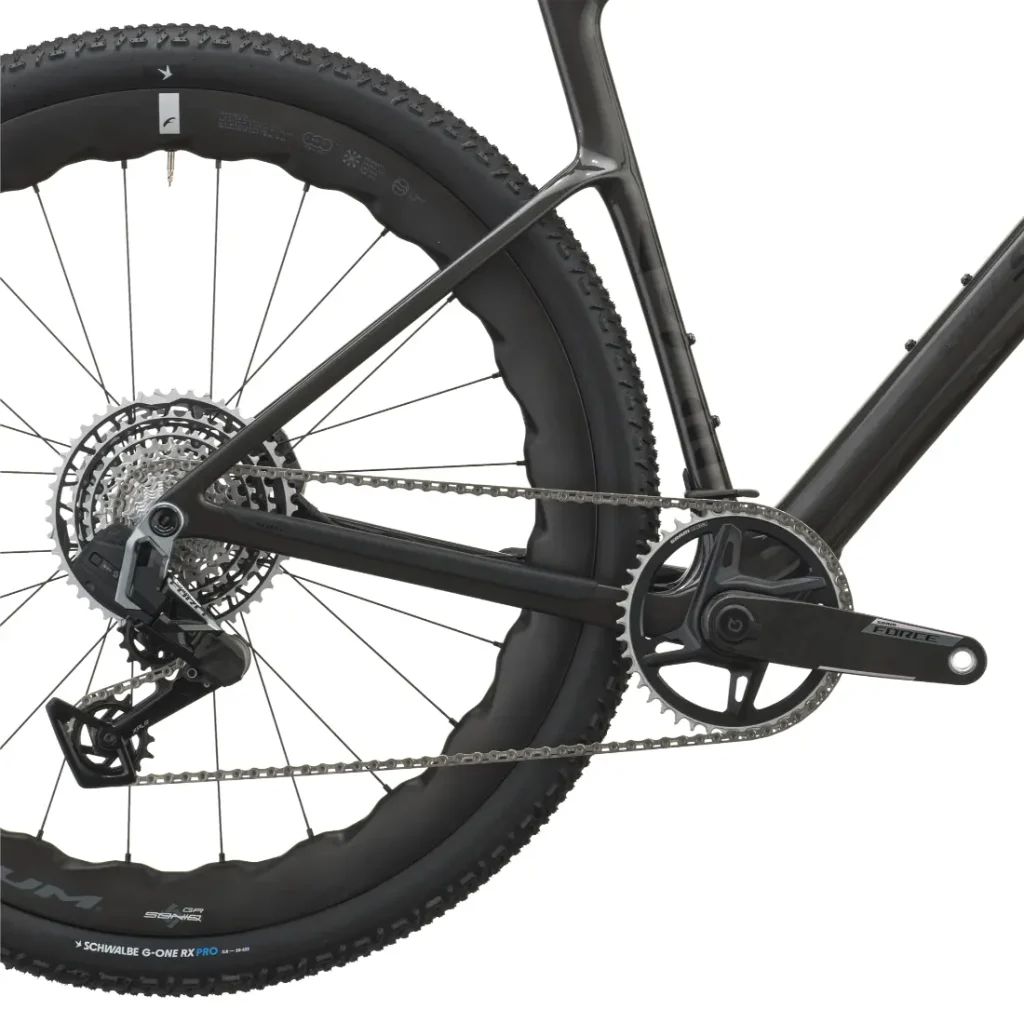 Primer plano de la rueda trasera, el cassette, el desviador y el juego de bielas de una bicicleta de gravel SCOTT Addict Gravel negra con una cubierta Schwalbe, en el que se destaca la ingeniería de precisión propia de los modelos de 2027.