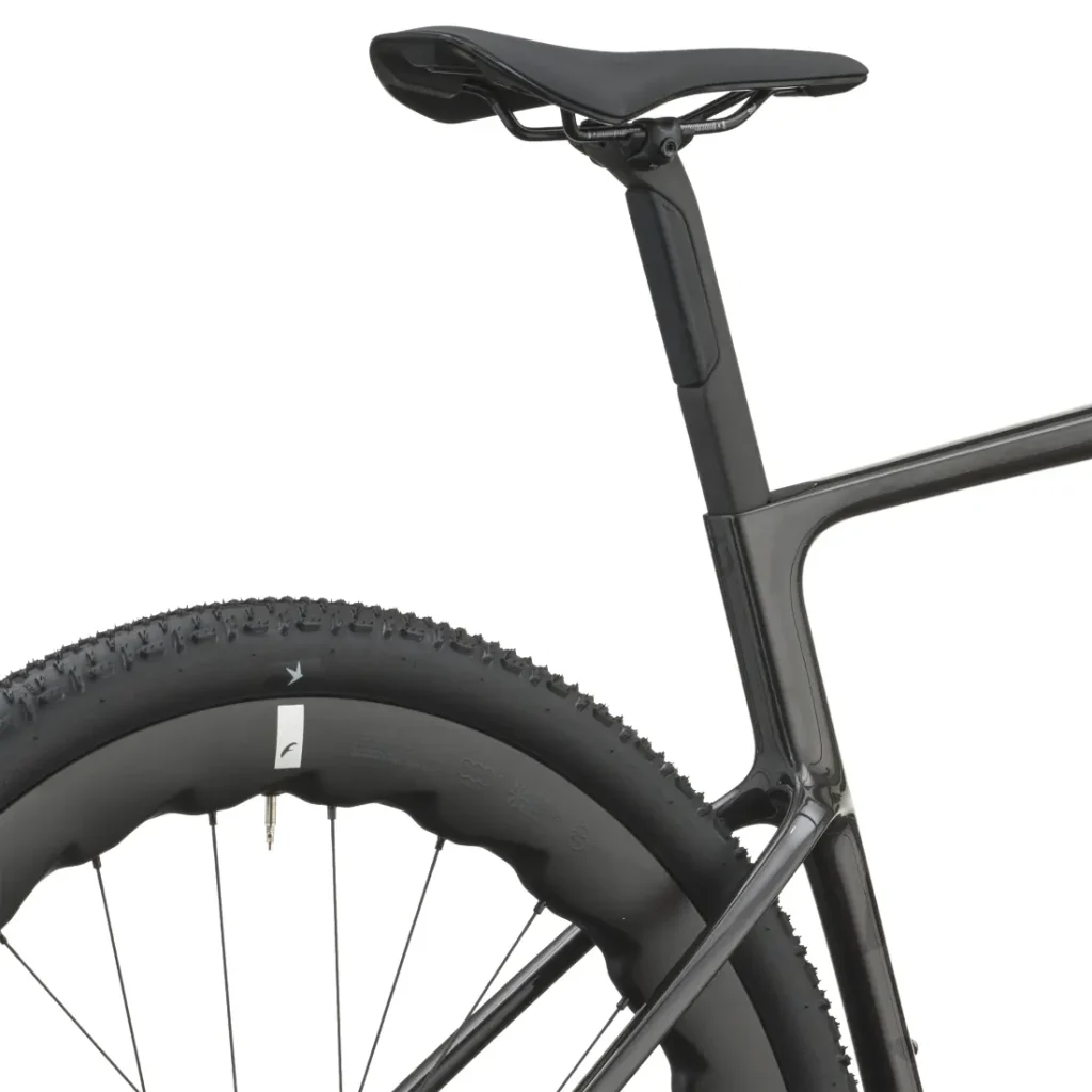 Primer plano de la rueda trasera, la tija del sillín y el sillín de una bicicleta negra SCOTT Addict Gravel 2027, en el que se aprecia la banda de rodadura del neumático y parte del cómodo y polivalente cuadro de la bicicleta, en una vista lateral sobre un fondo blanco.