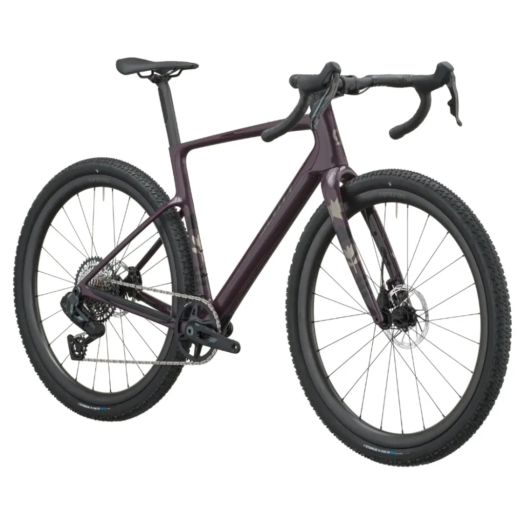 Se muestra una bicicleta SCOTT Addict Gravel 2027 de color morado oscuro, con manillar de carretera, frenos de disco y neumáticos anchos con tacos, vista de perfil sobre un fondo blanco. Esta bicicleta de gravel, polivalente y cómoda, está diseñada para ofrecer versatilidad y comodidad en cualquier terreno.