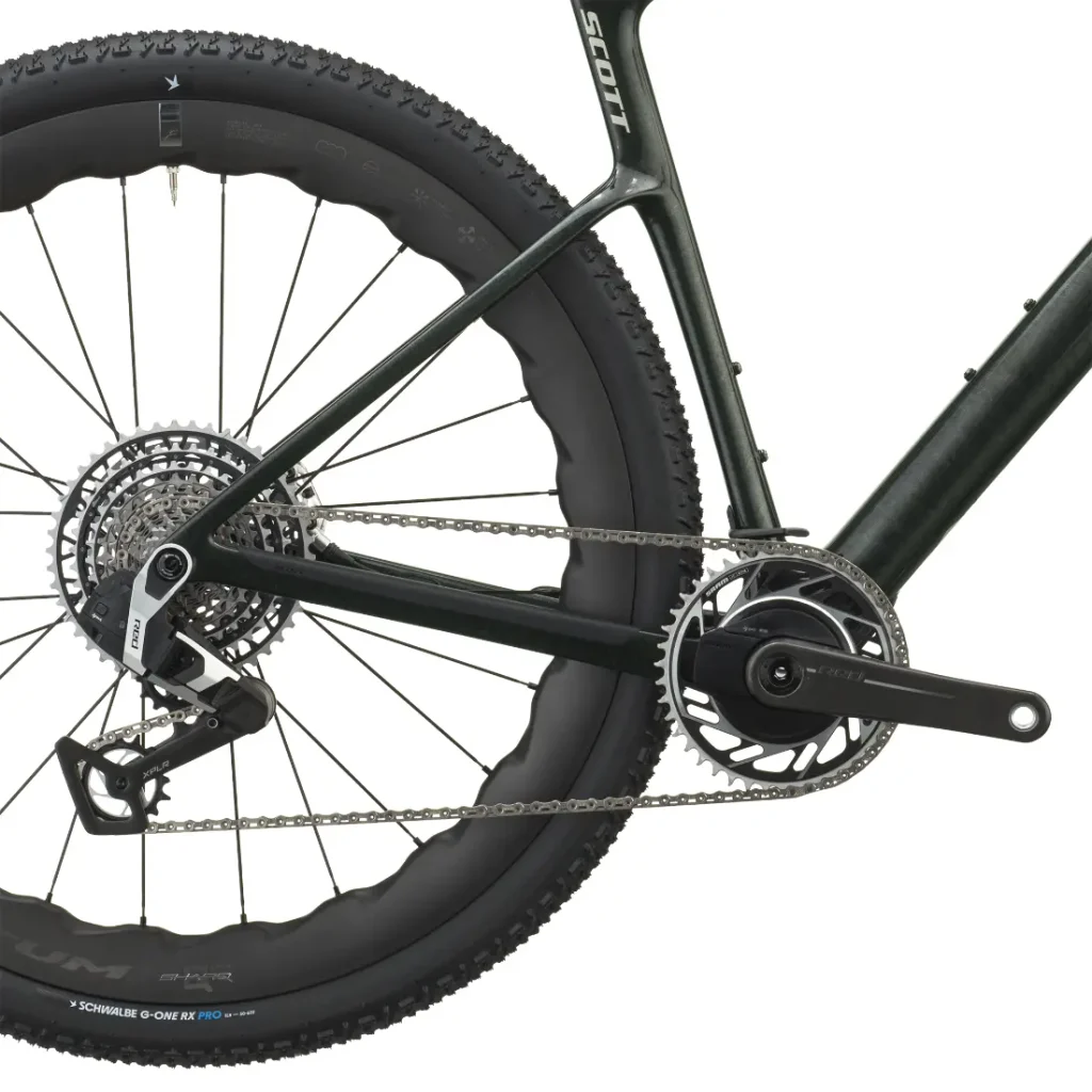 Primer plano de la rueda trasera, la cadena, el cassette, el desviador y el juego de bielas de una SCOTT Addict Gravel 2027 negra, en el que se aprecian los cómodos componentes de la transmisión y el triángulo trasero del cuadro de esta bicicleta de gravel.