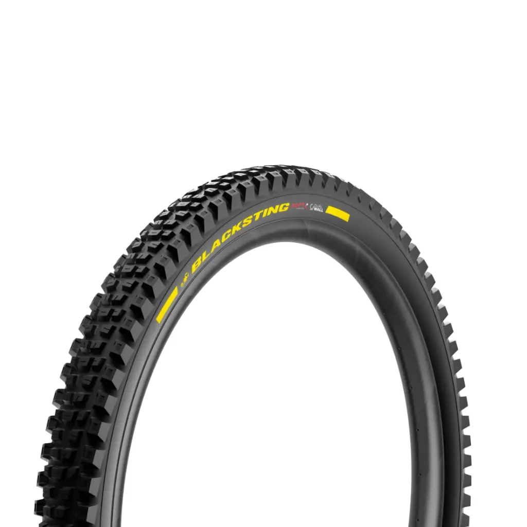 Una cubierta negra para bicicleta de montaña con un dibujo de banda de rodadura con tacos, inspirada en el ciclismo de gravedad y con la inscripción «BLACKSTING» en amarillo en el flanco, que recuerda a neumáticos de MTB de alta gama como el Pirelli Scorpion, representada sobre un fondo blanco.