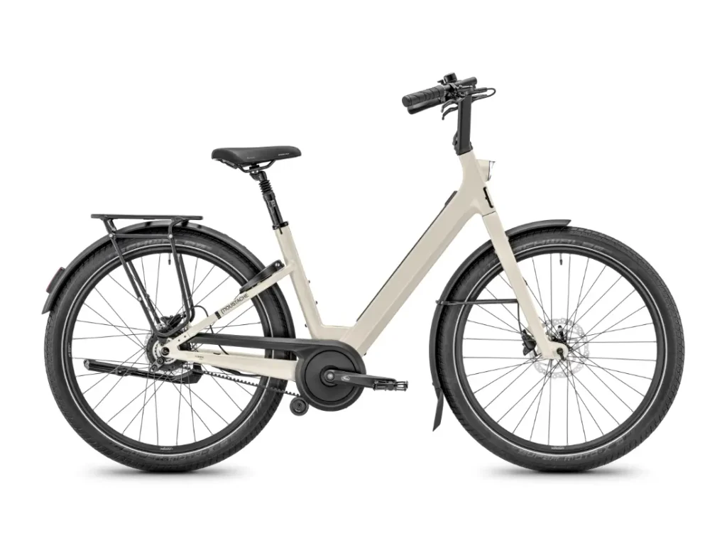 Bicicleta urbana «Beige Moustache Lundi 27» con cuadro de acceso fácil, neumáticos, sillín y manillar negros, equipada con portaequipajes trasero, guardabarros y protector de cadena —perfecta para explorar la ciudad—, vista de perfil sobre un fondo blanco.