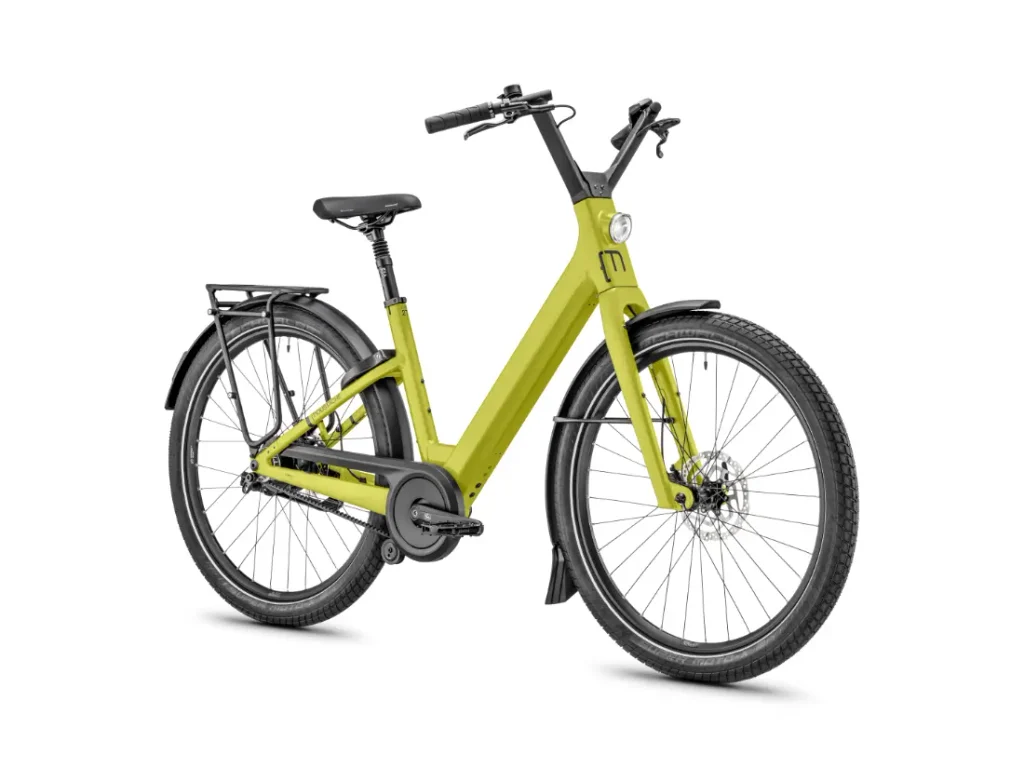 Una bicicleta eléctrica Moustache Lundi 27 de cuadro bajo, de color amarillo, con neumáticos negros, guardabarros y un portaequipajes trasero, perfecta para moverse por la ciudad, representada sobre un fondo blanco.