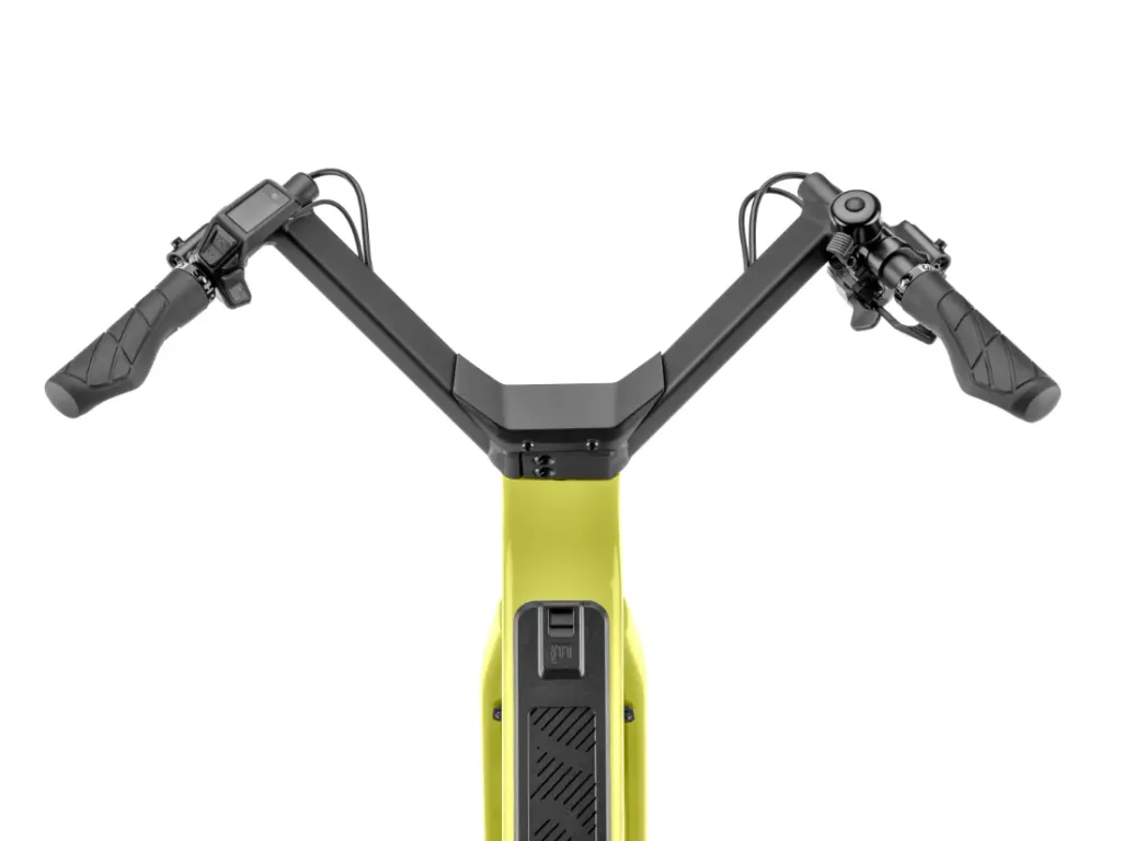 Vista de cerca del manillar y el panel de control de una bicicleta eléctrica amarilla «Moustache Lundi 27», en la que se aprecian los puños de control, las palancas de freno y la pantalla central desde una perspectiva frontal superior, ideal para moverse por la ciudad con estilo y comodidad.