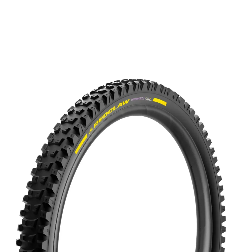 Una cubierta negra de bicicleta de montaña con un dibujo marcado y el logotipo amarillo «REDCLAW» sobre un fondo blanco: perfecta para los ciclistas de MTB de descenso que buscan el rendimiento de unas cubiertas de MTB de alta gama.
