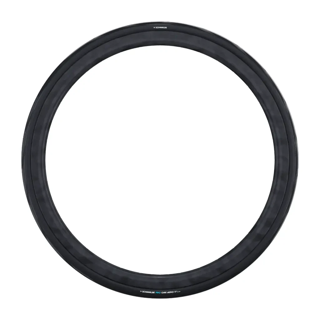 Se muestra una sola cubierta de bicicleta Schwalbe Pro One Aero de color negro sobre un fondo blanco, colocada en posición vertical para resaltar su forma circular y el dibujo de la banda de rodadura; es perfecta tanto para la rueda trasera como para la rueda delantera.