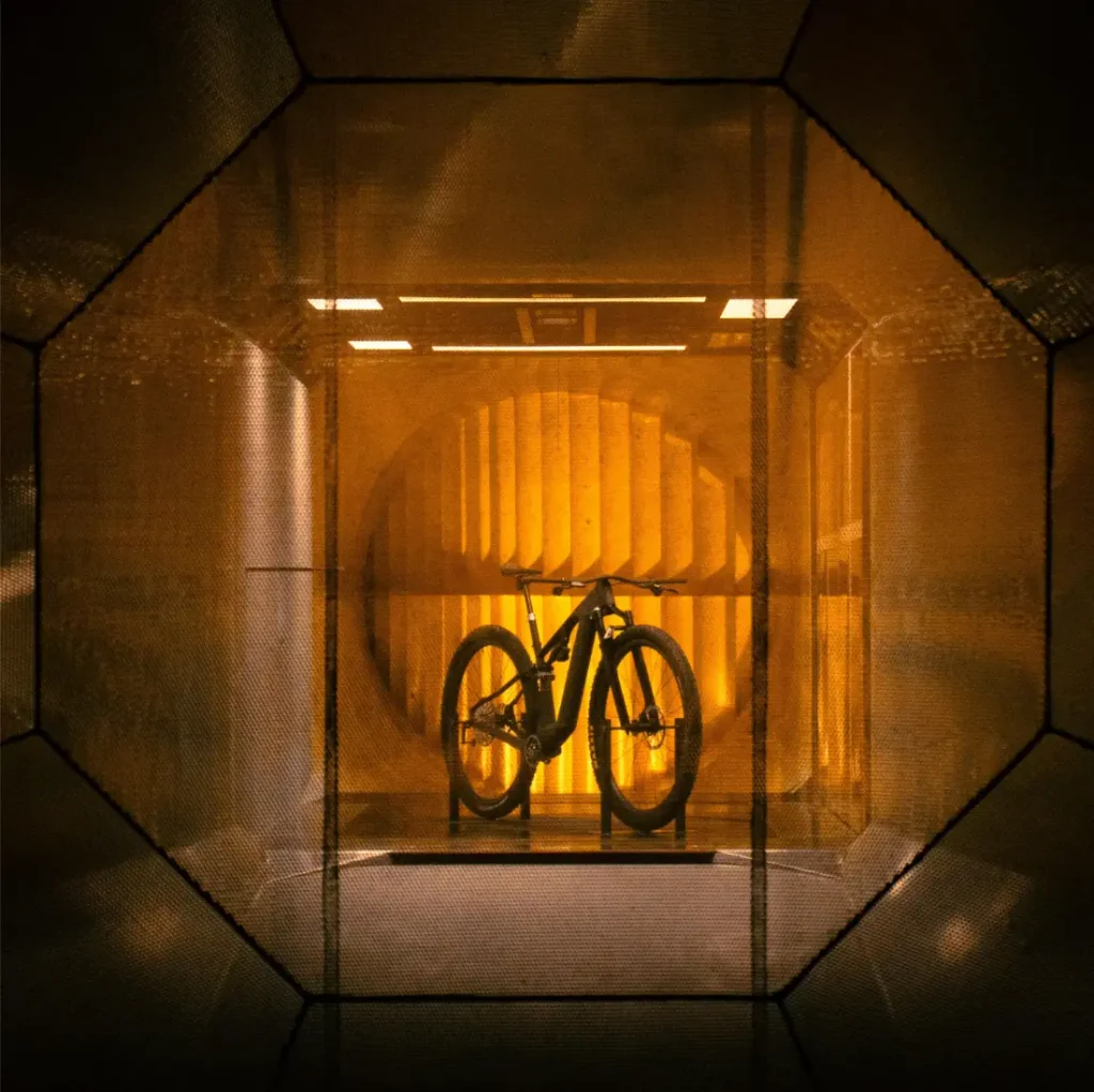Una bicicleta de montaña colocada sobre un soporte dentro de un túnel de viento.