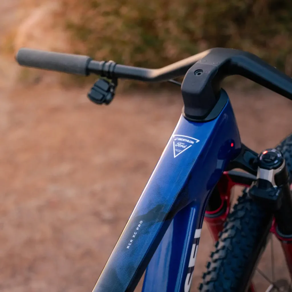 Primer plano del cuadro y el manillar de una bicicleta de montaña Ford RCR XC Pro azul de Decathlon.