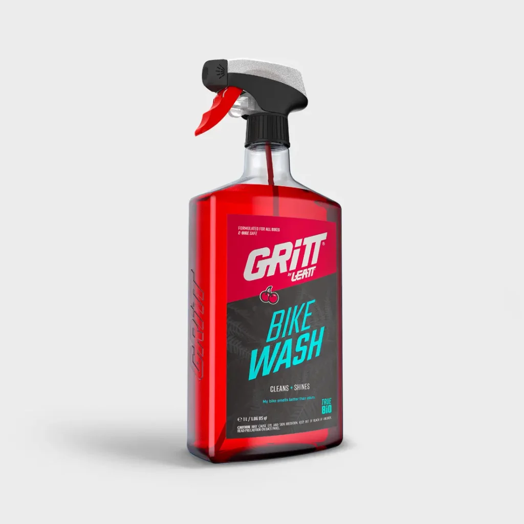 Una botella de limpiador para bicicletas Leatt Gritt con una boquilla pulverizadora roja y líquido limpiador rojo.