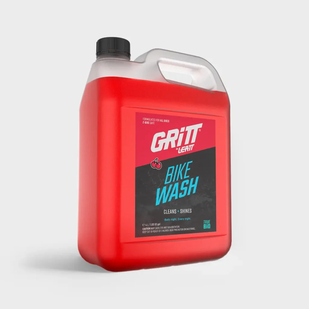 Botella de cuatro litros de «Gritt» de Leatt para lavar la bicicleta, con un líquido de color rojo brillante y un tapón de rosca negro.