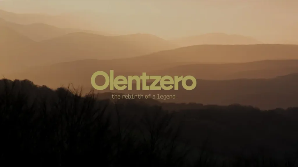 Texto que reza «Olentzero: el renacimiento de una leyenda», centrado sobre un paisaje montañoso dorado y difuminado.