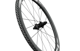En un fondo blanco se muestra una rueda de bicicleta Zipp 404 S con buje negro, radios negros y una llanta de fibra de carbono gris con motivos blancos, diseñada para la velocidad y el máximo rendimiento.