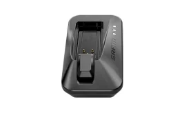 Un cargador de batería SRAM negro con clavijas de carga y luces indicadoras LED sobre un fondo blanco, presentado entre las Novedades SRAM febrero 2026.