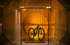Una bicicleta de montaña colocada sobre un soporte dentro de un túnel de viento.
