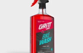 Una botella de limpiador para bicicletas Leatt Gritt con una boquilla pulverizadora roja y líquido limpiador rojo.