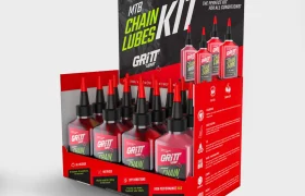 Expositor de botellas de lubricante para cadenas Gritt para bicicletas de montaña, con información del producto impresa en los laterales y en la parte superior trasera.