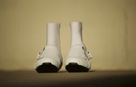 Un par de zapatillas de ciclismo de invierno Northwave Celsius R Arctic GTX blancas con protectores de tobillo integrados, vistas desde delante.