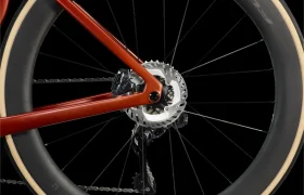 Primer plano de la rueda trasera de una LOOK 795 Blade RS 3, en el que se aprecian el freno de disco, el desviador, la cadena y parte del cuadro rojo sobre un fondo negro.