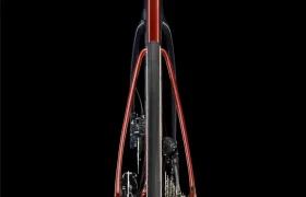 Vista trasera del cuadro y la transmisión de una bicicleta LOOK 795 Blade RS 3, en la que destacan el cuadro, la rueda trasera, los frenos y los cambios de color rojo sobre un fondo negro: un elegante homenaje a la artesanía de Nevers.