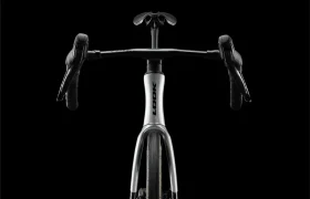 Vista frontal de una moderna bicicleta de carretera LOOK 795 Blade RS 3 con manillar de carretera, sobre un fondo negro. La palabra «LOOK» es visible en el cuadro de la bicicleta, fabricado con precisión en Nevers.