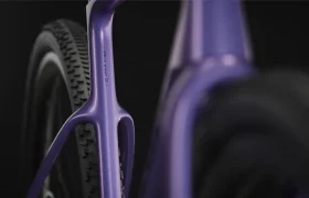 Primer plano del cuadro morado de la bicicleta SCOTT Addict Gravel 2027, con especial atención a la rueda trasera y el neumático, en el que destaca su diseño polivalente y cómodo sobre un fondo oscuro.