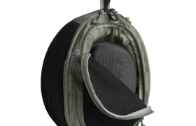 Una bolsa de transporte compacta con cremallera de la colección ASSOS x Db con panel frontal de malla, asa lateral y clip de sujeción, ideal para ciclistas y para mantener tus objetos esenciales organizados en cualquier sistema de viaje. Se muestra parcialmente abierta sobre fondo blanco.