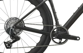 Primer plano de la rueda trasera, el cassette, el desviador y el juego de bielas de una bicicleta de gravel SCOTT Addict Gravel negra con una cubierta Schwalbe, en el que se destaca la ingeniería de precisión propia de los modelos de 2027.