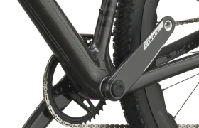 Primer plano de la transmisión de una bicicleta SCOTT Addict Gravel 2027 negra, en el que se aprecian el juego de bielas, el plato, la cadena y parte de la rueda trasera con un dibujo de banda de rodadura con tacos, lo que ilustra a la perfección el carácter polivalente de esta bicicleta de gravel.
