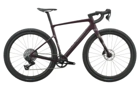 Se muestra de perfil, sobre un fondo blanco, una bicicleta gravel SCOTT Addict Gravel 2027 de color morado oscuro, con manillar de carretera, neumáticos anchos y cuadro de carbono, que combina un diseño elegante con una posición de conducción cómoda.