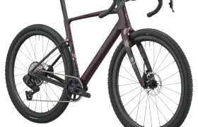 Se muestra una bicicleta SCOTT Addict Gravel 2027 de color morado oscuro, con manillar de carretera, frenos de disco y neumáticos anchos con tacos, vista de perfil sobre un fondo blanco. Esta bicicleta de gravel, polivalente y cómoda, está diseñada para ofrecer versatilidad y comodidad en cualquier terreno.