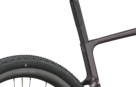 Primer plano de la parte trasera de una bicicleta, en el que se aprecian el sillín, la tija del sillín, parte del cuadro y la rueda trasera, con la banda de rodadura del neumático visible y el logotipo de Synchros en la llanta. El modelo SCOTT Addict Gravel 2027 aporta un toque de diseño moderno a esta configuración preparada para el gravel.
