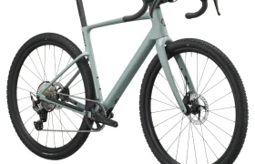 En un fondo blanco se muestra una bicicleta gravel SCOTT Addict Gravel 2027 de color verde claro, con manillar de carretera, frenos de disco y neumáticos con tacos, colocada en ángulo para resaltar su cuadro polivalente y su transmisión trasera.