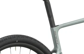 Primer plano del cuadro gris claro de una bicicleta de gravel, en el que se aprecian el sillín, la tija del sillín y la rueda trasera con la banda de rodadura visible. La marca «Scott» aparece impresa en el cuadro, lo que destaca la cómoda y versátil SCOTT Addict Gravel 2027.