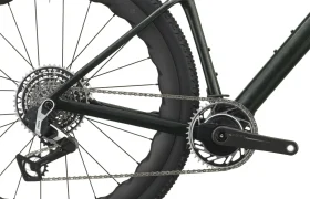 Primer plano de la rueda trasera, la cadena, el cassette, el desviador y el juego de bielas de una SCOTT Addict Gravel 2027 negra, en el que se aprecian los cómodos componentes de la transmisión y el triángulo trasero del cuadro de esta bicicleta de gravel.