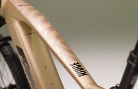 Primer plano de un cuadro dorado Fantic e-MTB que muestra la palabra "RIDGE" y un dibujo estilizado en el tubo superior, propulsado por un motor Bosch CX Gen5.