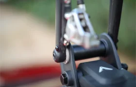 Primer plano de un componente mecánico de una bicicleta, que muestra parte de la pinza de freno, un tornillo y una sección del cuadro, perfecta para fijarla con un soporte Allen Smart Suction Bike Rack.